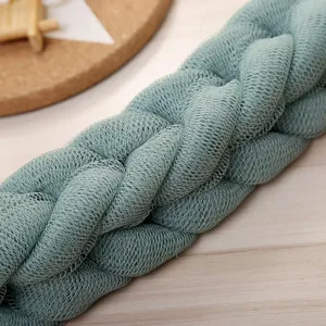 Detailed view of a green mesh bath scrubber, soft exfoliating back strap for shower use.