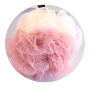 Gros plan sur la texture en filet du sponge de bain doux bicolore rose et blanc délicat.