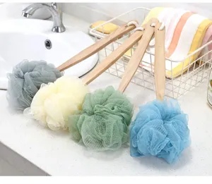 Vue détaillée de brosses de bain en bois à long manche avec fleurs de douche en maille colorée.