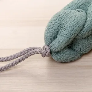 Green mesh bath sponge detail shot, soft texture back scrubber with hanging cord for daily use