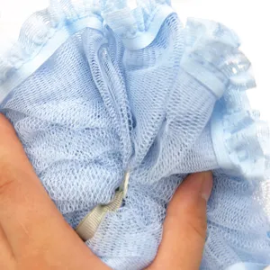 Detalle de esponja de baño de malla azul, puff de ducha suave con volante de encaje corporal.