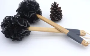 Detailaufnahme des Buerstenkopfes, schwarzer Duschschwamm mit langem Holzgriff und Griff.