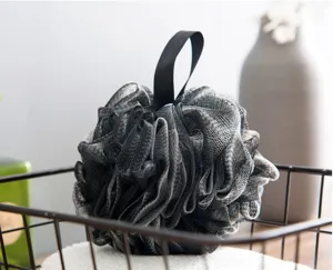Close-up of black mesh bath sponge puff showing soft textured PE material for gentle shower foaming.