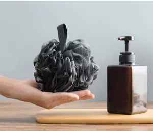 Detailed view of the black bamboo charcoal bath sponge mesh ball, ultra-soft and foaming.