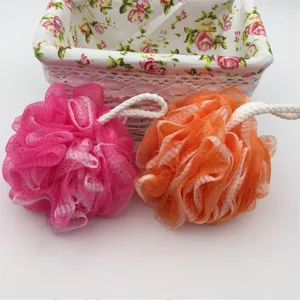 Close-up detail of vibrant pink and orange mesh shower bath sponges featuring hanging cords.