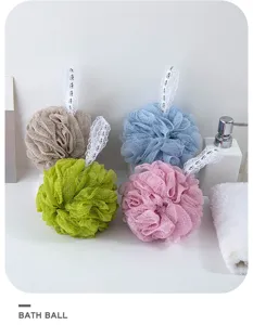 Detailed view of colorful mesh bath sponges with lace hanging loops, soft texture for body wash.