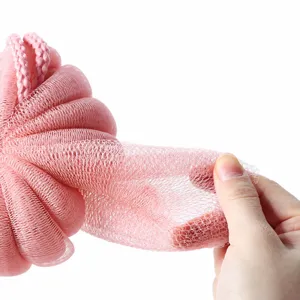Pink mesh bath sponge shower loofah puff for body cleaning, soft foaming net stretched by hand.
