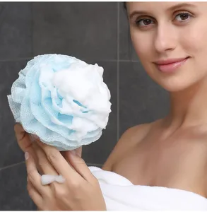 Vista detallada de una suave esponja de baño de nylon azul con espuma blanca rica.