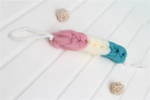 Close-up detail of the multi-colored back scrubber with hanging loops and mesh texture.