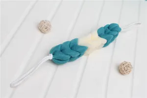 Detail view of the Nordic style braided mesh bath sponge scrubber in teal and beige.