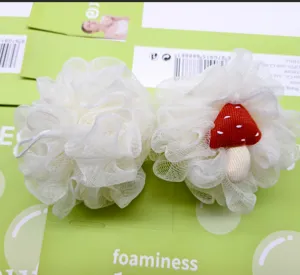 Detalles de primer plano de la esponja de baño blanca con bonita decoración de setas.