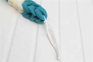 Close-up detail of the dual-color braided mesh bath scrubber with a white hanging loop.