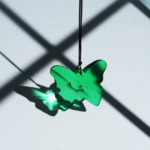 Green crystal butterfly pendant suncatcher with black hanging cord for home garden decor.