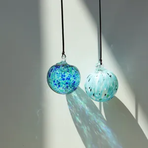 Hanging blown glass sun catcher balls with blue speckled design for wonderful light refraction.