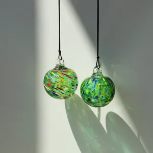 Handmade blown glass suncatcher hanging ball with colorful swirls for garden and home decor.