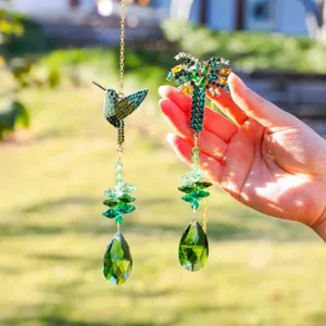 Crystal suncatcher detail showing hummingbird and palm tree pendants with green crystals.