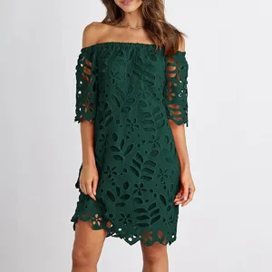 Vestido de encaje verde oscuro con hombros descubiertos y media manga, falda corta floral calada.
