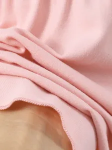 Primo piano dettagliato della texture del tessuto rosa di abito, materiale morbido.