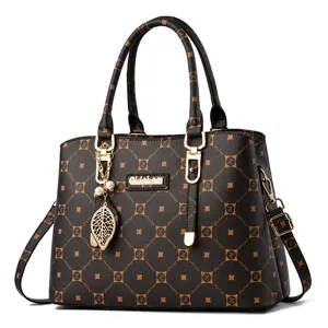 Élégant sac à main fourre-tout monogrammé pour femme avec poignées et charmant pendentif.