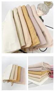 Detail view of soft solid cashmere-feel winter scarf tassel close up texture display.