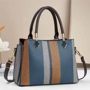 Gros plan détail du sac à main rayé color-block pour femme à double poignée et bandoulière.