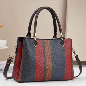 Vue rapprochée du détail de sac à main rayé color-block élégant aux poignées structurées.