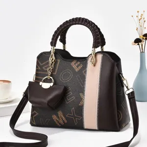 Vista dettagliata della borsa a spalla marrone in pelle con motivo monogramma e manico intrecciato.