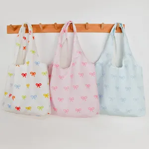 Canvas tote bag with cute bow print, casual large capacity shoulder bag for women daily commute.