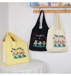 Canvas tote bag detail showing cute cartoon print, large capacity, casual shoulder style.