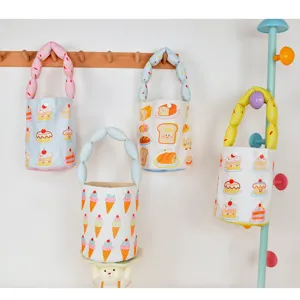 Detailed view of cute canvas bucket bag with cartoon prints, ideal for kids travel.