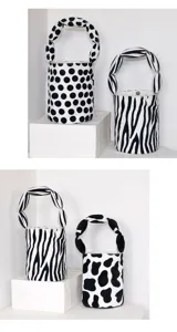 Canvas bucket bag with unique twisted handle, black and white pattern handbag for daily use.