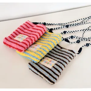 Close-up detail view of cozy plush striped crossbody phone bags with stylish straps.