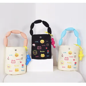 Canvas bucket bag detail showcasing cute embroidered patterns and unique bubble handles clearly.