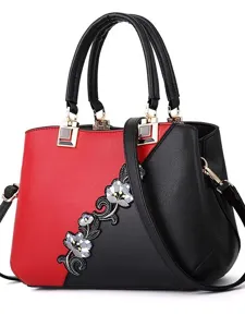 Elegante bolso de mano color block para mujer con bordado floral y correa cruzada.