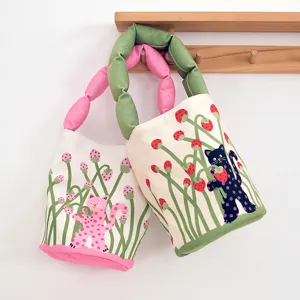 Detailed view of canvas bucket bags featuring cute polka dot cat prints and bubble handles.