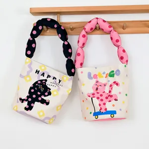 Canvas bucket handbag with cute cat print and padded polka dot handles for daily casual use.