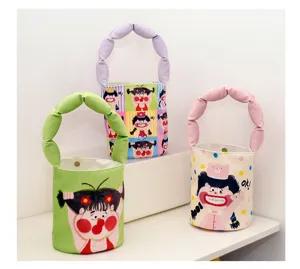 Small canvas bucket bag detail featuring puffy handle and cute cartoon character print design.