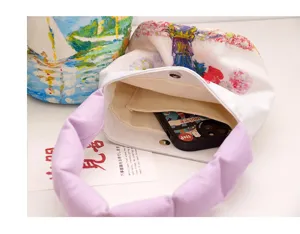 Detailed view of women small canvas bucket bag with retro oil painting print and purple handle.