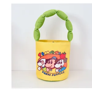 Detailed view of cute cartoon dog print yellow bucket bag with green puffy handle design.