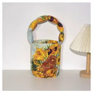 Detail view of a vintage Van Gogh sunflower print bucket handbag with padded twisted handle.