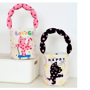 Detail view of canvas bucket bag with cute cat graphic and unique puffy polka-dot handle.