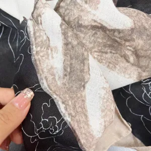 Gros plan montrant la texture de tissu douce et le motif floral de camélia élégant.