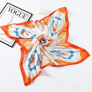 Detalle de pañuelo cuadrado de seda que muestra un pliegue artístico de mariposa con patrones.
