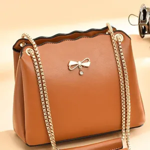Élégant sac à bandoulière marron pour femme avec chaîne dorée et nœud mignon vue principale.
