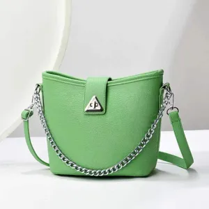 Détail de sac seau vert montrant une texture en cuir premium et une élégante chaîne argentée.