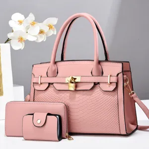 Schicke rosafarbene Handtasche im Set mit Geldbörse und Kartenetui in eleganter Schlangenoptik.