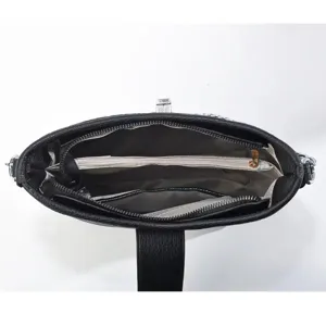 Détail intérieur de sac à main en cuir noir avec plusieurs compartiments zippés.
