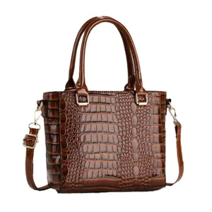 Klassieke bruine krokodillenpatroon lakleer dames handtas en crossbody tas met handvatten.