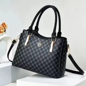 Detalle de primer plano del bolso de mujer con monograma clásico y elegante cierre metálico duradero.