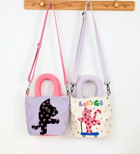 Detailed shot of cute canvas bucket bags with polka dot cat patterns and chunky handles.